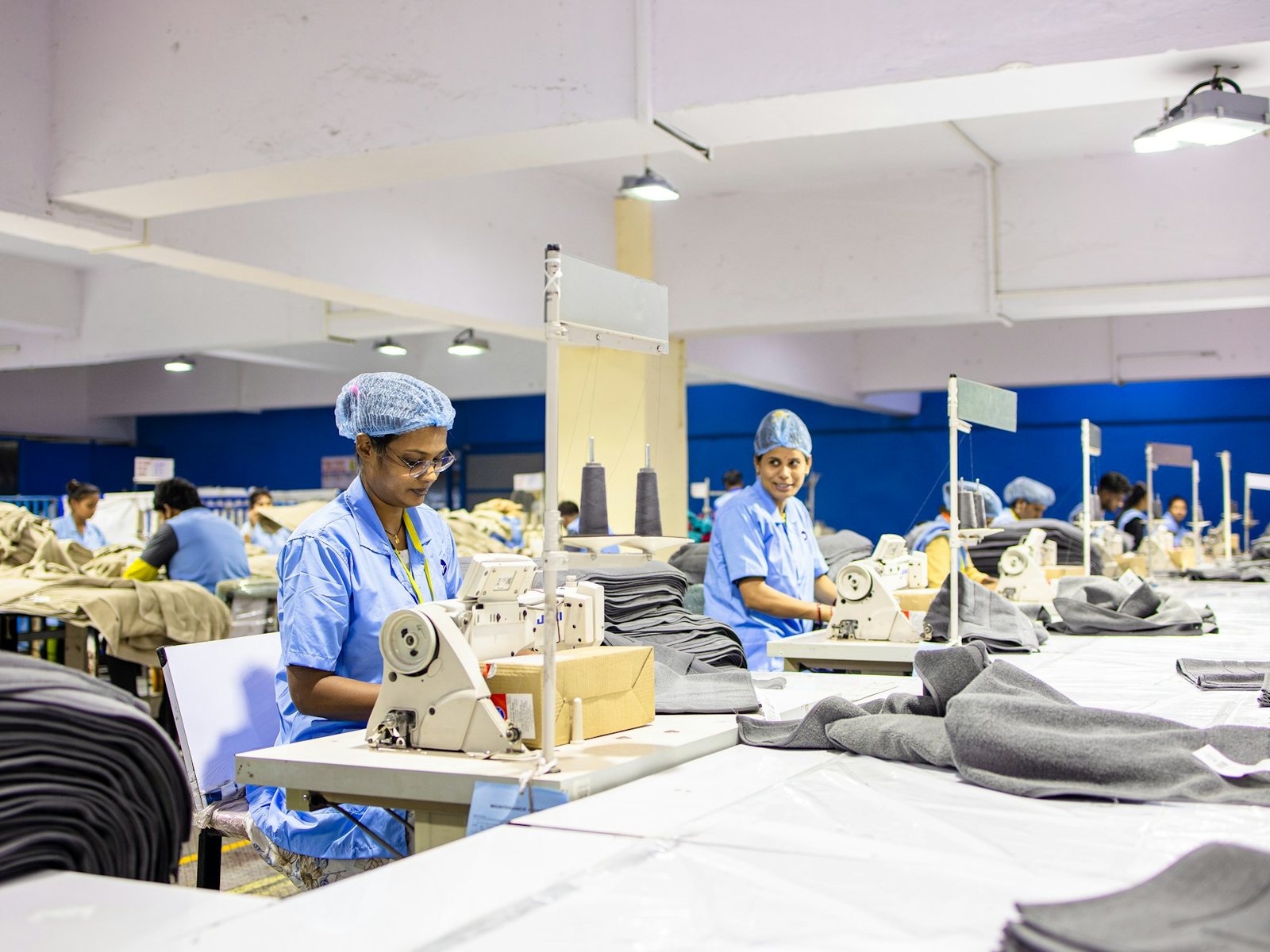 Garment workers at sewing machines on a production line