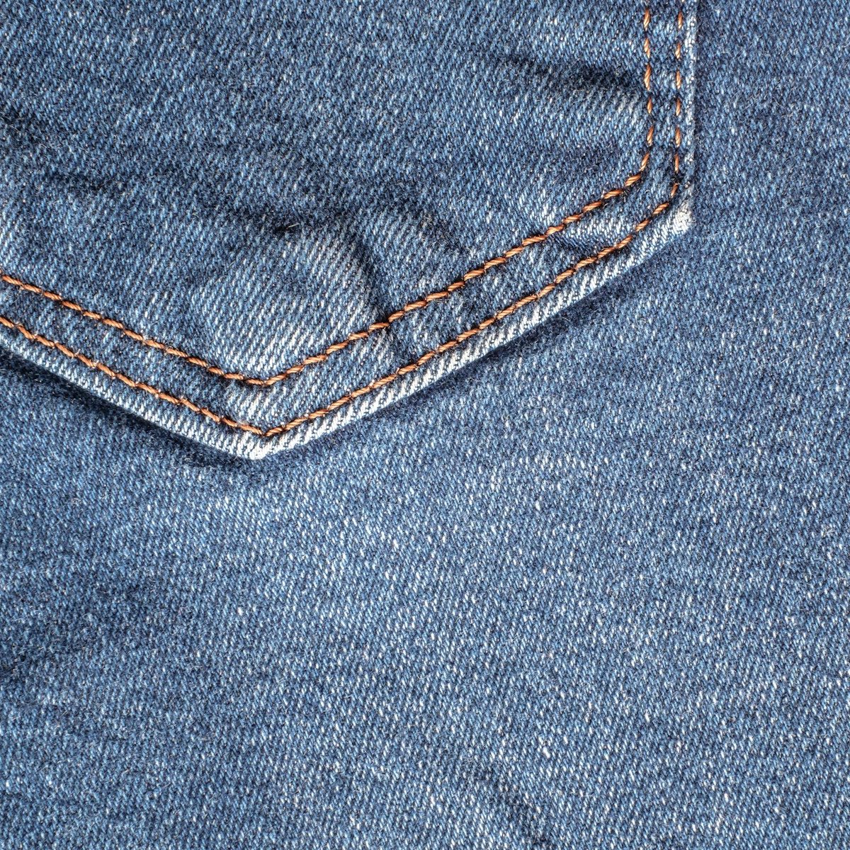 Macro detail of a denim pocket seam with contrast topstitching